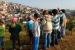 Antes da pandemia Covid-19, professora Carmen e alunos da Escola de Resiliência estão próximos a horta biodinâmica e observam a paisagem construída no Horizonte Azul<br />Foto William Rodrigues 