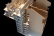 Vista da maquete em construção onde se nota a implantação da proposta sobre a estrutura preexistência (o terreno em dois níveis separados por uma contenção e as paredes divisórias entre as quatro casas), bem como os pátios internos e as passarelas<br />Imagem dos autores do projeto 