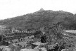 Fig. 4 - Provavelmente a foto mais antiga do Park Güell. Mostra o início das obras, com algumas mudas de palmeira já plantadas (esquerda, abaixo). Percebe-se o estado de degradação da encosta, com uma vegetação raquítica em meio às pedras [Cátedra Gaudí, Barcelona]
