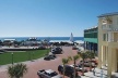 Fig. 17: Seaside - Central Square: à esquerda o Amphiteather, que é um espaço gramado, à direita no segundo plano, edifício comercial projetado por Machado and Silvetti Associates 1995, à direita ao fundo, a torre projetada por Leon Krier Architects, 1998 [Ópticos Design Inc. Image file, 2008]