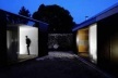Espaço exterior entre o corpo da garagem (esq.) e o corpo principal da casa