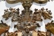 Brasão da Ordem do Carmo ladeado por dois querubins esvoaçantes e encimado pela cabeça de um terceiro, sustentando a coroa da Virgem, motivo central da portada da Igreja de Nossa Senhora do Carmo, Aleijadinho (atribuição), Ouro Preto MG, 2014<br />Foto Elio Moroni Filho 