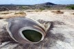 Foto 1 - O lajedo, circundado pelo cariri tendo, ao fundo, elevações isoladas e, em primeiro plano, um pequeno lago quase seco