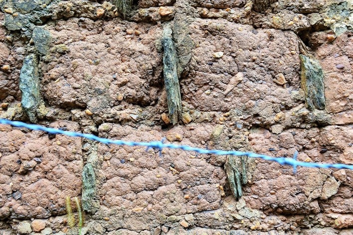 Seixos na composição dos tijolos de adobe e cacos de telha ou pedra entre os adobes, no muro de adobe retelhado e sem reboco, em Diamantina MG, 2014<br />Foto Elio Moroni Filho 
