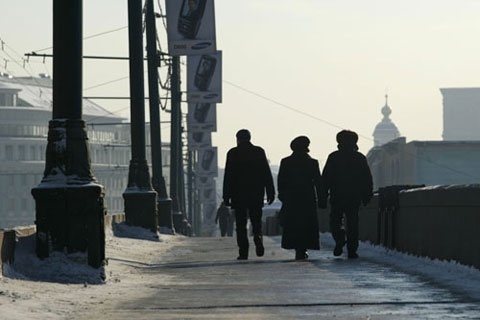 Moscovitas passeiam por ponte sobre o Rio Moscou