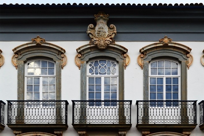 Portas-sacadas com trabalhos em cantaria e escultura, tendo, acima da porta-sacada central, tarja ornada em volutas, com relevo representando a Virgem cercada de estrelas e, inferiormente, o Monte Carmelo, fachada do Museu Arquidiocesano, Mariana MG, 2014<br />Foto Elio Moroni Filho 