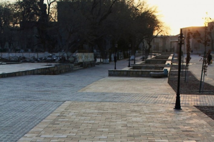 Vista do corredor de circulação ao longo da face sul da Praça Lyabi-Hauz, em Bukhara. O pequeno trecho de canalização fechada do córrego é destacado no desenho do piso - o curso d'água faz-se presente mesmo quando não visível<br />Foto José Júlio Rodrigues Vieira 