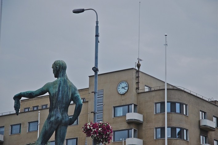 Arte urbana, escultura na Ponte Hämeensilta sobre o rio Tammerkoski no centro urbano com edificação preservada ao fundo<br />Foto Fabio Lima 