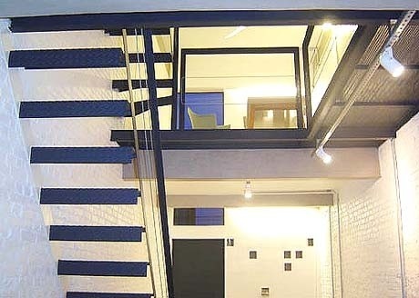 Vista de parte do térreo e do mezanino. Detalhe da escada engastada e do vão de iluminação<br />Imagem dos autores do projeto 