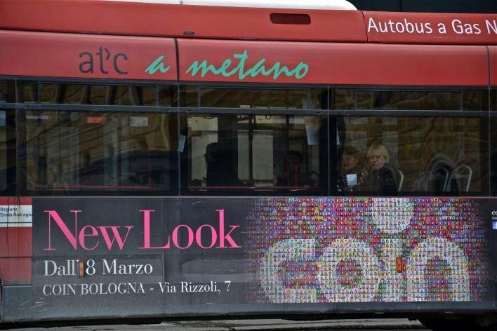 Bologna Centrale refletida em ônibus a metano, com engenho publicitário<br />Foto Fabio Jose Martins de Lima 