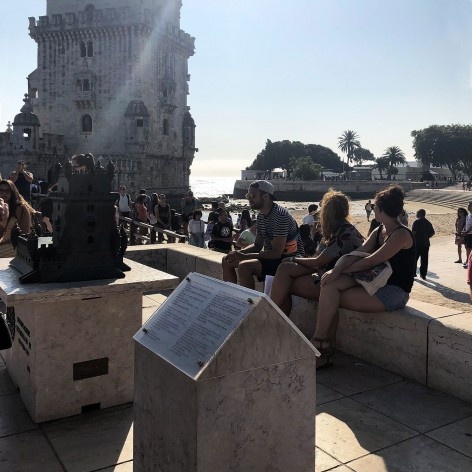 Totem com informações em Braille, maquete tátil e, ao fundo, a Torre de Belém, Lisboa<br />Foto Larissa Scarano, 2018 
