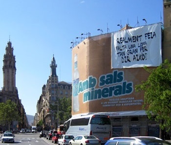 Intervenção anônima sobre lona publicitária em fachada de Barcelona<br />Foto Xico Costa 