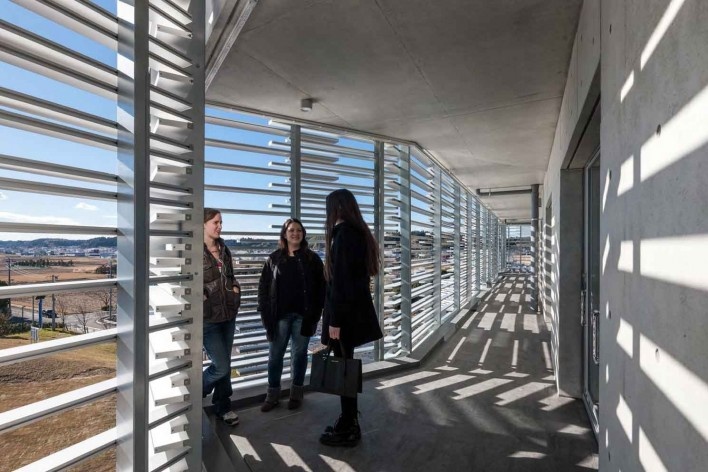 Alojamento Estudantil, circulação externa entremeada de balcões em balanço e aberta ao exterior permite espaços para fumantes, Josai International University, Togane, Japão, 2014-2016, Studio Sumo<br />Foto Kawasumi Kobayashi  [Studio Sumo]