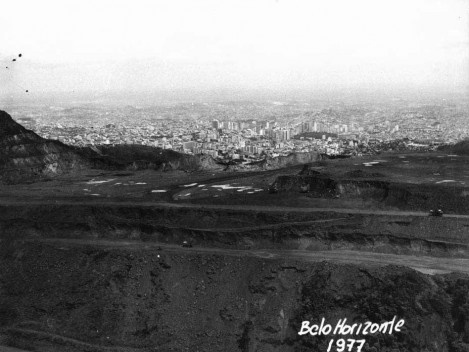 Fotografia tirada a partir da Serra do Curral que mostra mina de minério de ferro que foi explorada pela Ferrobel até 1979. Observa-se no canto superior esquerdo os taludes recortados pela atividade mineraria [Coleção José Góes, APM, 1977.]
