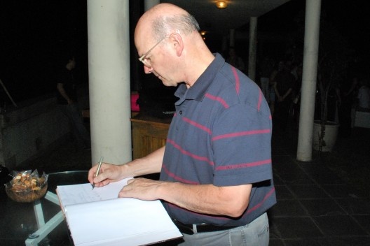 Guto Lacaz escrevendo no livro de dedicatórias da festa<br />Foto Thomas Bussius 