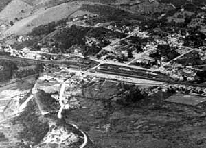 Ao fundo, Núcleo Colonial, ferrovia e páteo ferroviário Em primeiro plano, Rua do Comércio e Morro de Santo Antônio (removido), vôo sem data [Acervo do Museu de Ribeirão Pires]