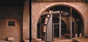 Páteo da Alfândega. À esquerda a epígrafe comemorativa da ampliação de 1432; ao centro a aduelas do arco do alpendre da torre medieval. <br />Fotografia: Ferreira Alves 