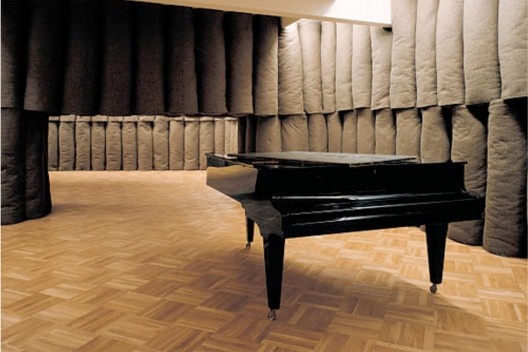 Joseph Beuys, Plight. Instalação com 43 elementos de feltro cinza com 5 rolos cada um, piano, quadro preto, termômetro, 3,10x8,90x13,15, Centre Georges Pompidou, Paris. [HUCHET, S. Intenções Espaciais. P. 210.]
