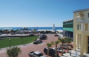 Fig. 17: Seaside - Central Square: à esquerda o Amphiteather, que é um espaço gramado, à direita no segundo plano, edifício comercial projetado por Machado and Silvetti Associates 1995, à direita ao fundo, a torre projetada por Leon Krier Architects, 1998 [Ópticos Design Inc. Image file, 2008]