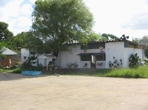 Espaço de convívio e moradia. Diante dele o amplo pátio de entrada e a generosa sobra da árvore